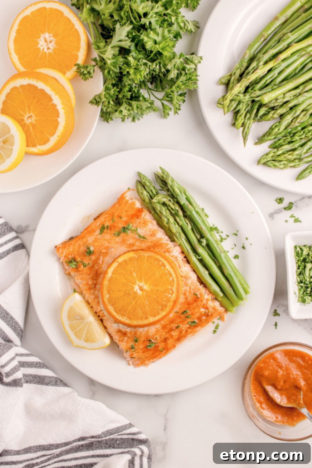 Simple Grilled Honey Mustard Salmon Foil Packets 15 overhead look of table with Grilled Honey Mustard Salmon on plate, asparagus, sliced orange, and more