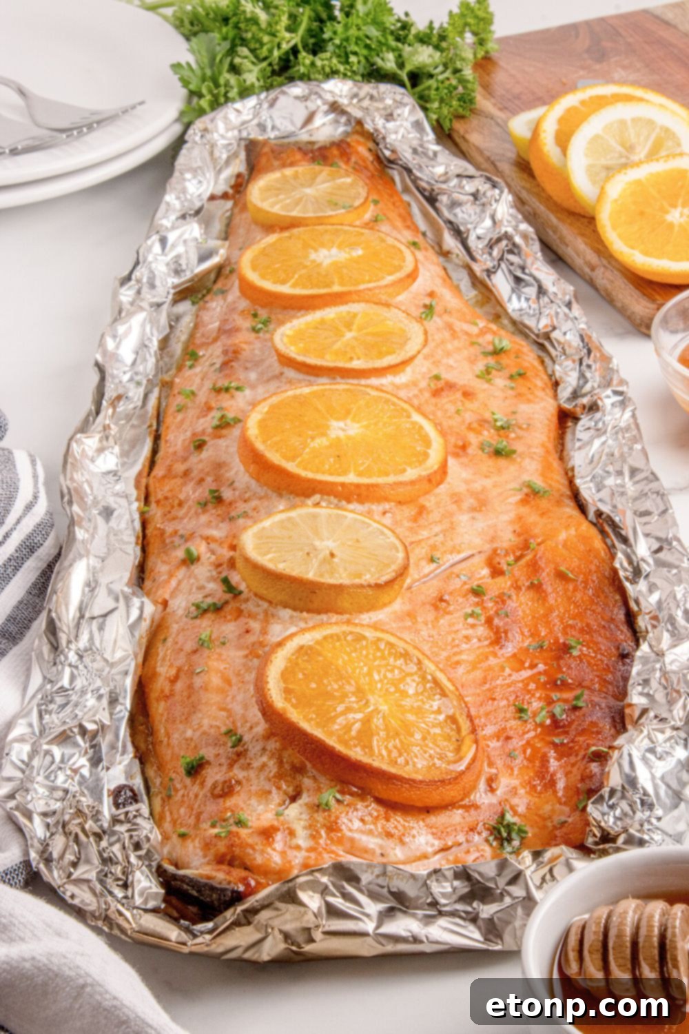 Simple Grilled Honey Mustard Salmon Foil Packets 18 Grilled Honey Mustard Salmon in Foil on table with a bowl of honey to side, sliced oranges, and more around table