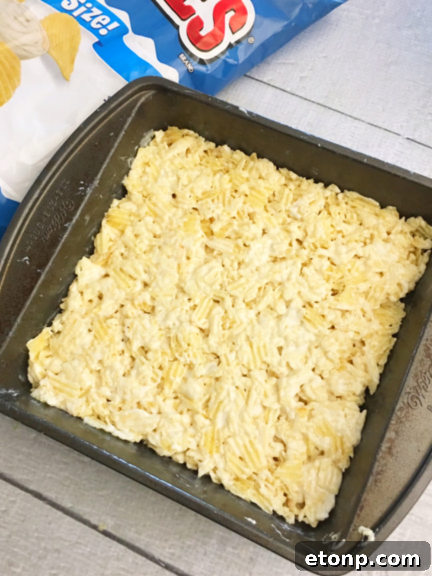Melted marshmallows and butter in a microwave-safe bowl, showing the creamy base for the treats.