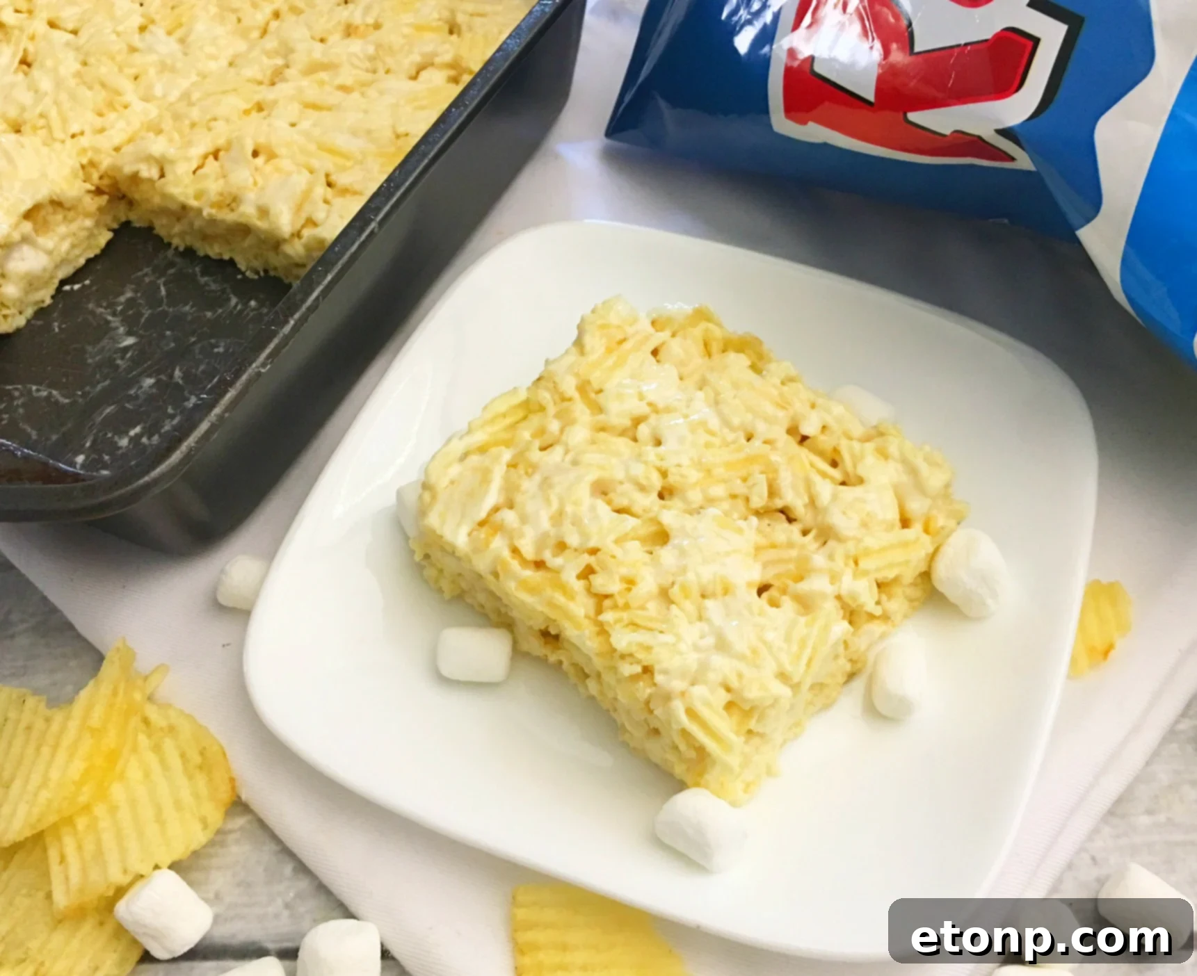 Crushed Ruffles potato chips being mixed into melted marshmallow and butter, showing the combining process.