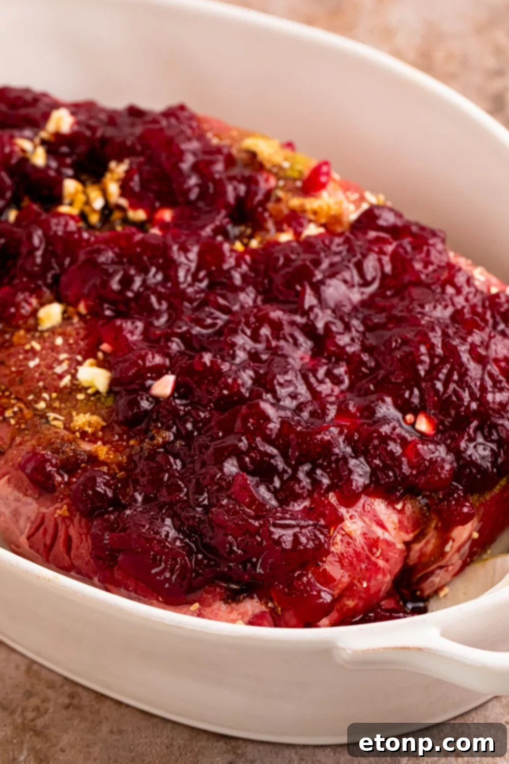 close up of raw Cranberry Pot Roast in pan with cranberry sauce on top 