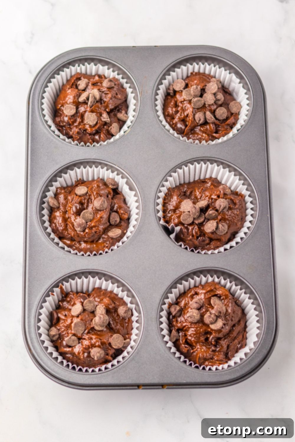 Costco Double Chocolate Muffins Bakery Style Jumbo Rich Moist 11 Raw Costco Double Chocolate Muffin batter scooped into a muffin pan.