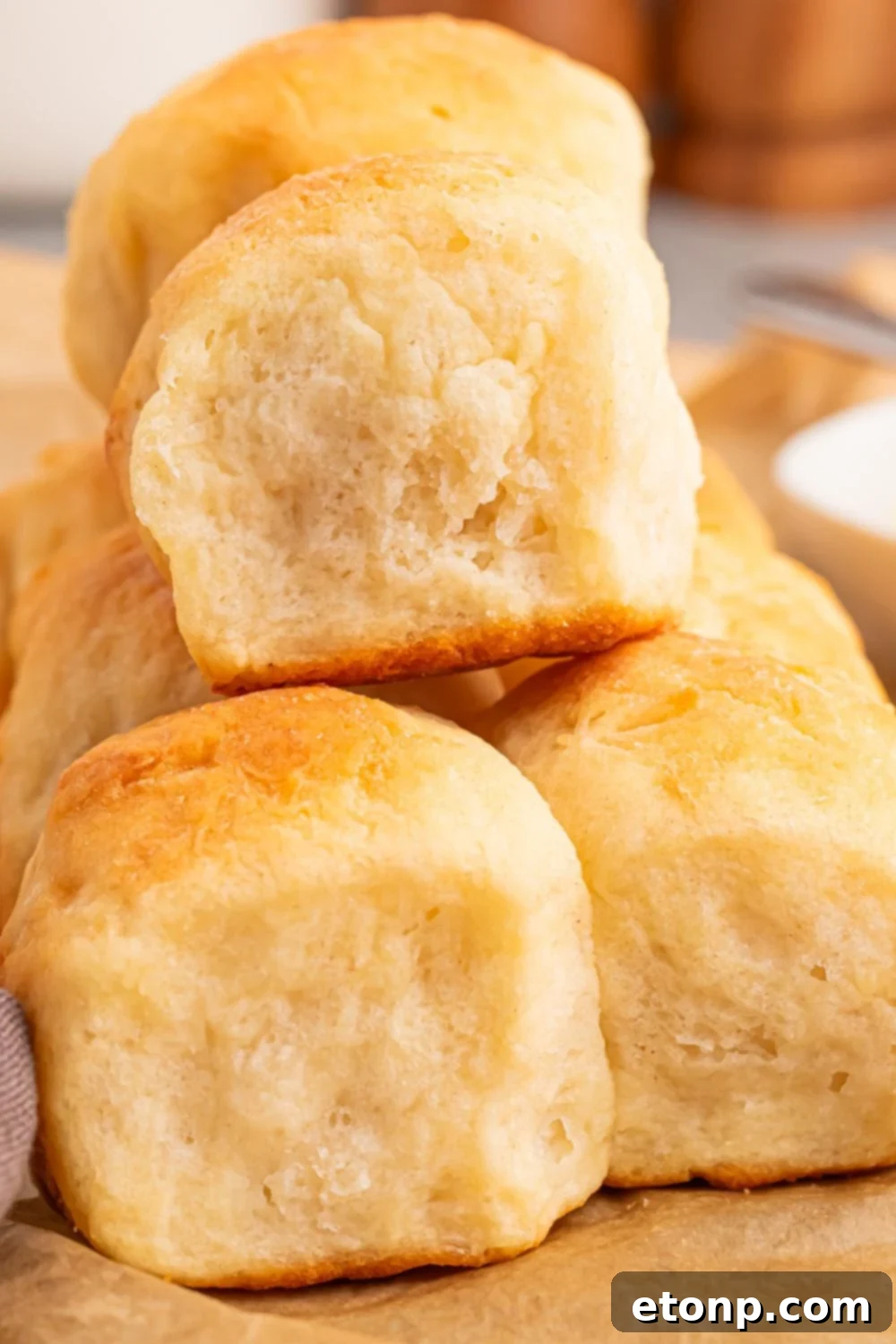 2 Ingredient Dinner Rolls stacked on table with salt and pepper behind it 