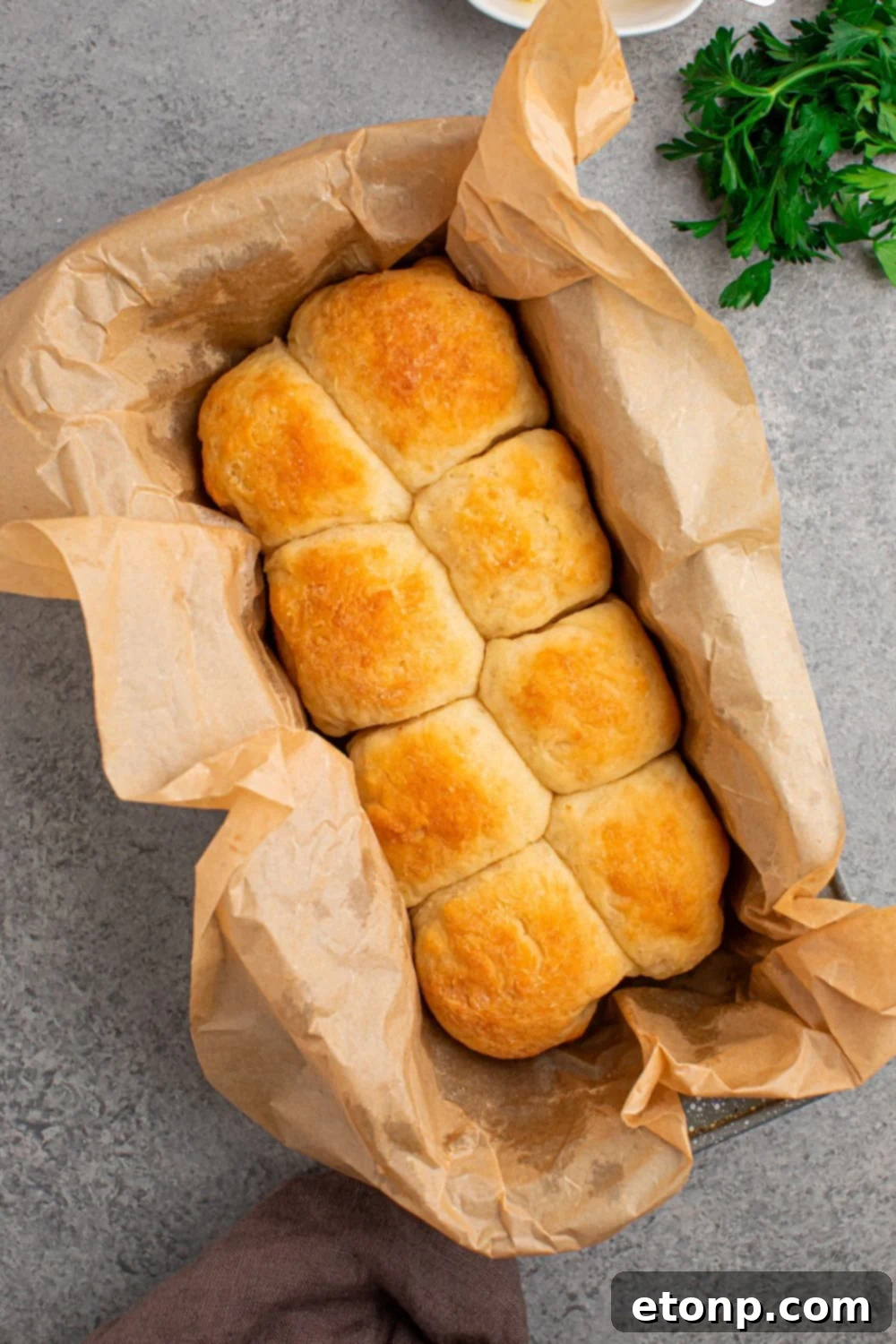 dinner rolls in pan with parchment paper sitting on table 