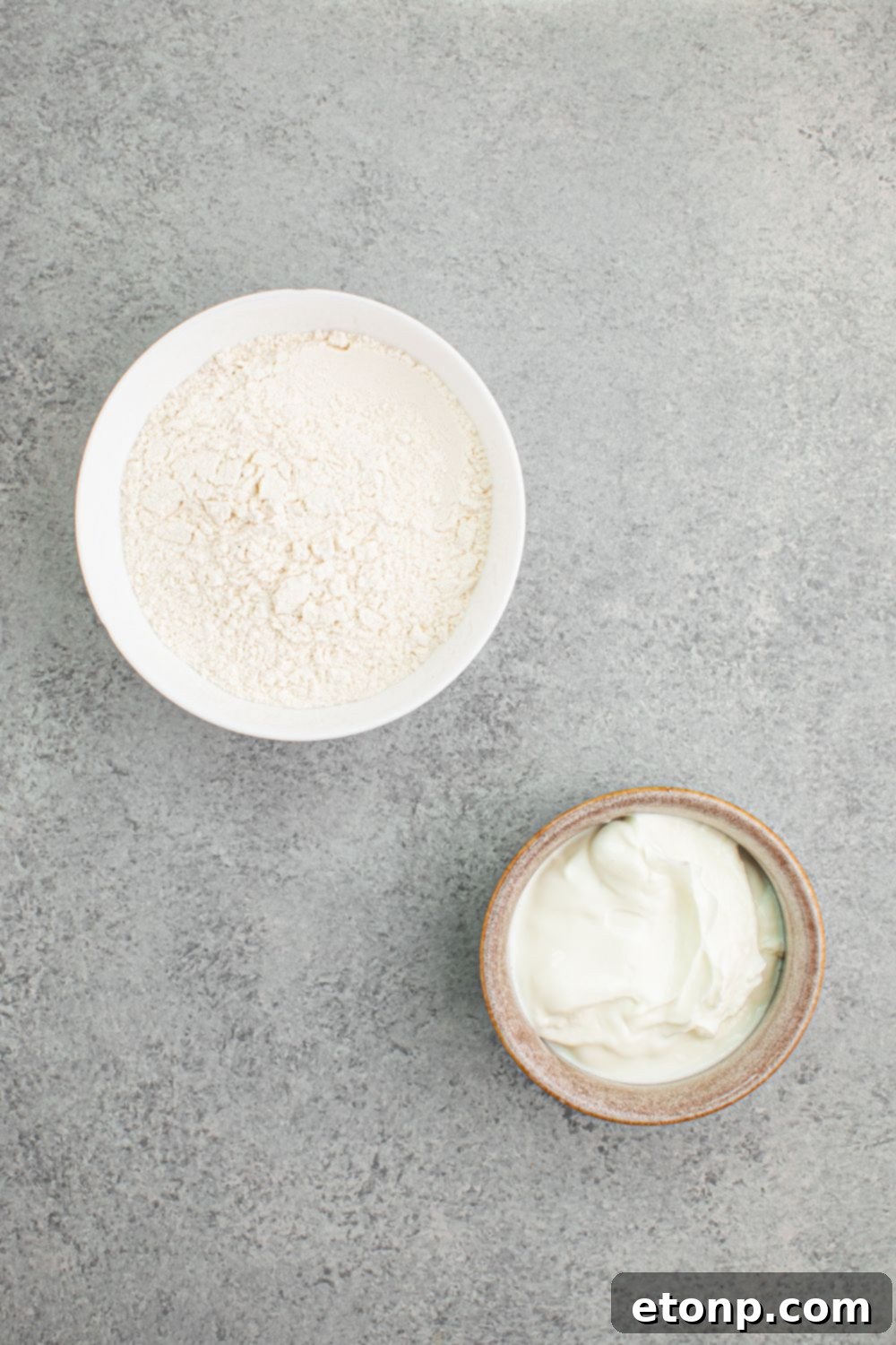 flour and Greek yogurt in bowls on table for making 2 Ingredient Dinner Rolls