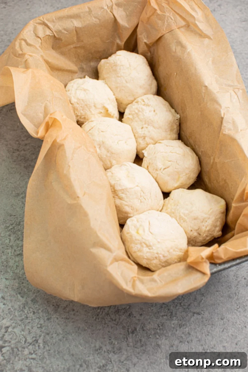 raw 2 Ingredient Dinner Rolls in pan with parchment paper 