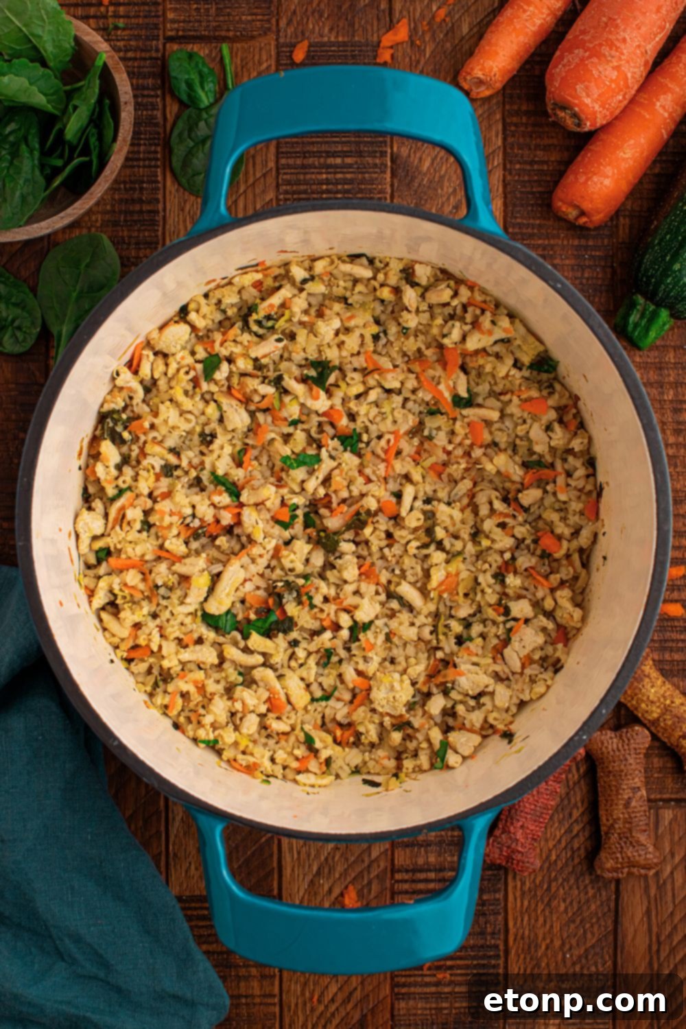Homemade Turkey and Rice Dog Food with Veggies in a stock pot sitting on table with ingredients around table 