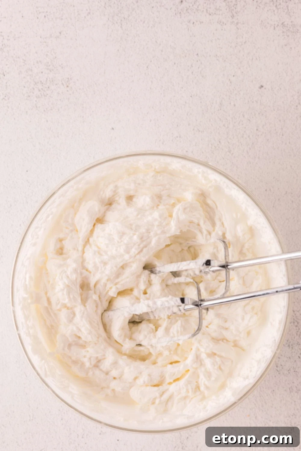 bowl with the start of a cheesecake batter being mixed in pan 