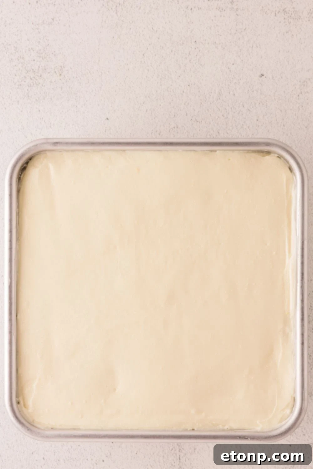 No Bake Banana Pudding Cheesecake Bar batter in a pan on table 