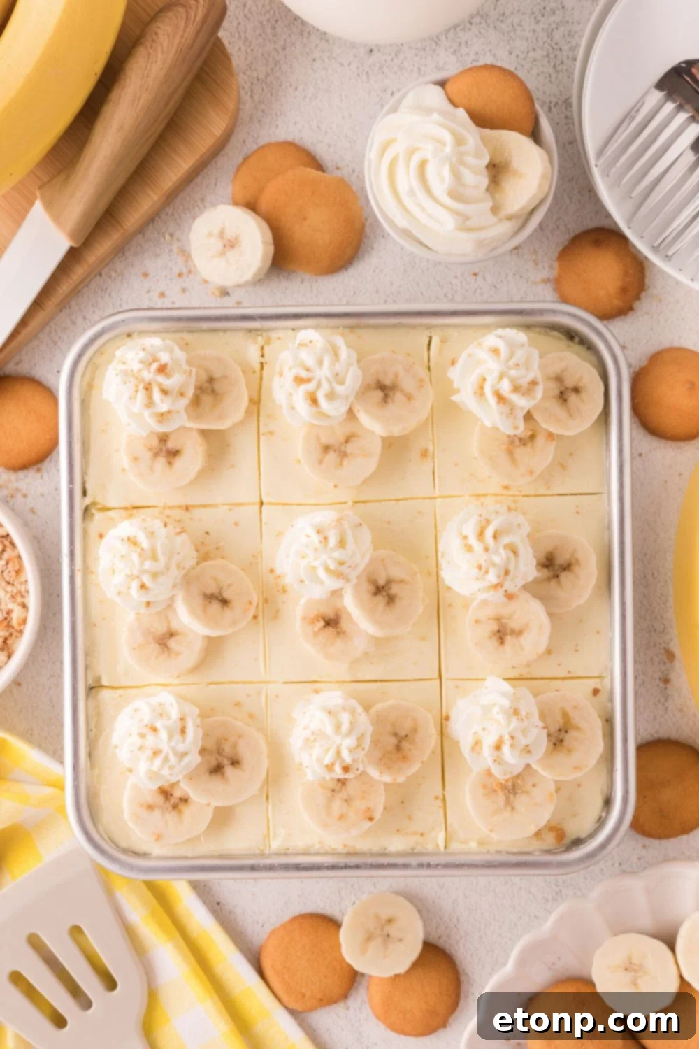 assembled and decorated No Bake Banana Pudding Cheesecake Bars in pan on table 