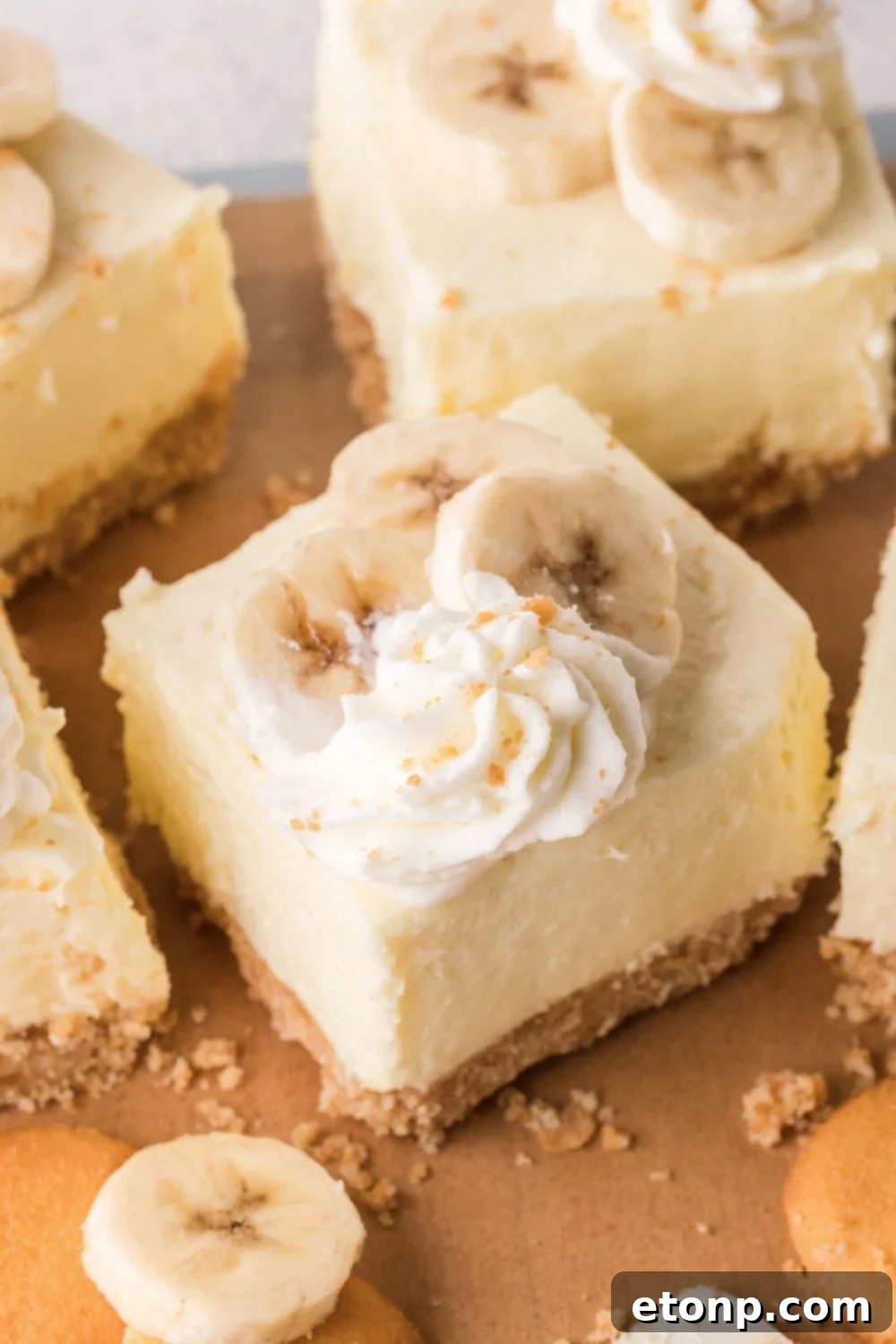 overhead look of sliced No Bake Banana Pudding Cheesecake Bars placed on table with some crumbs around the table 