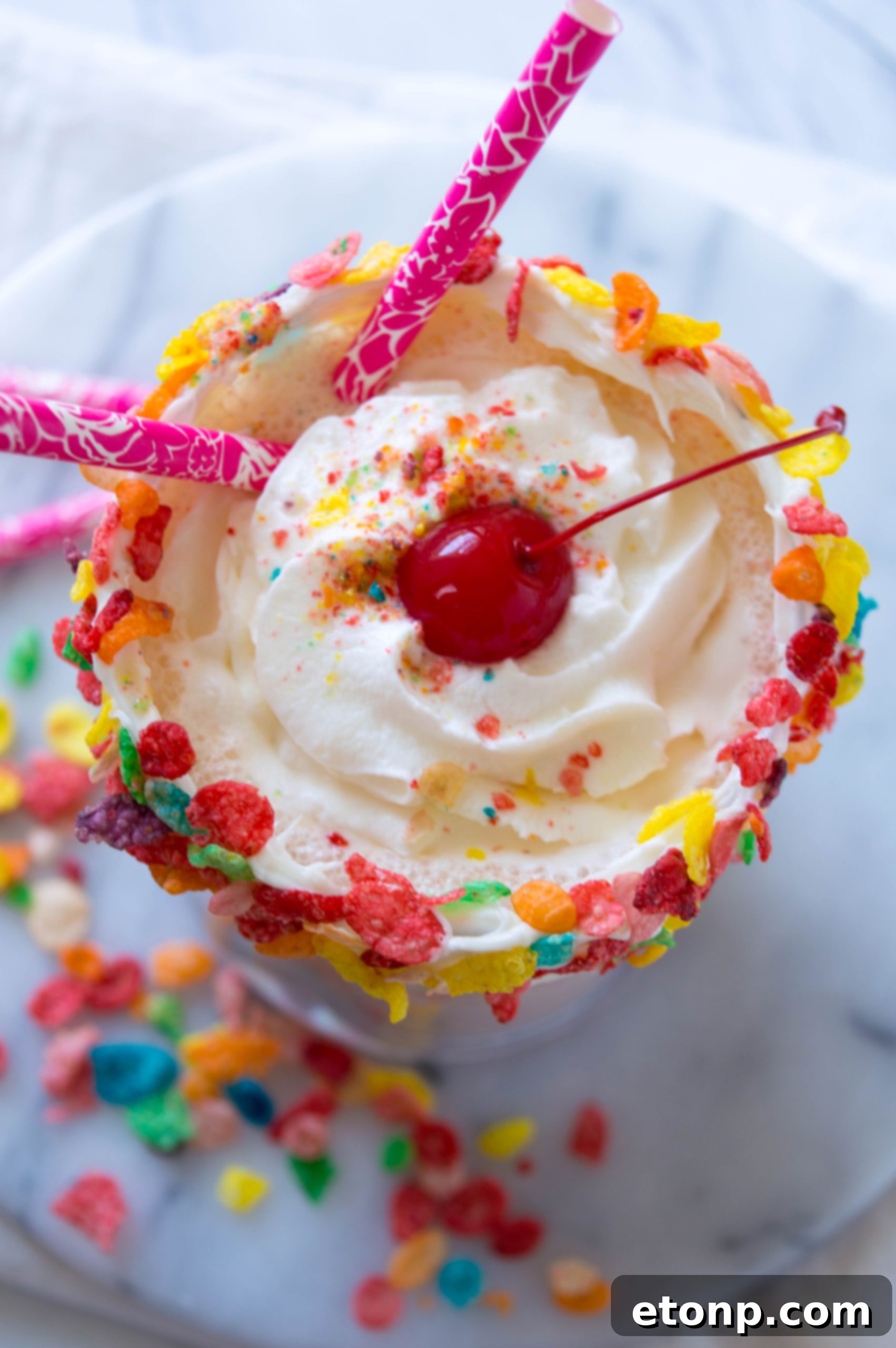 A delicious Adult Fruity Pebbles Milkshake topped with whipped cream and colorful cereal