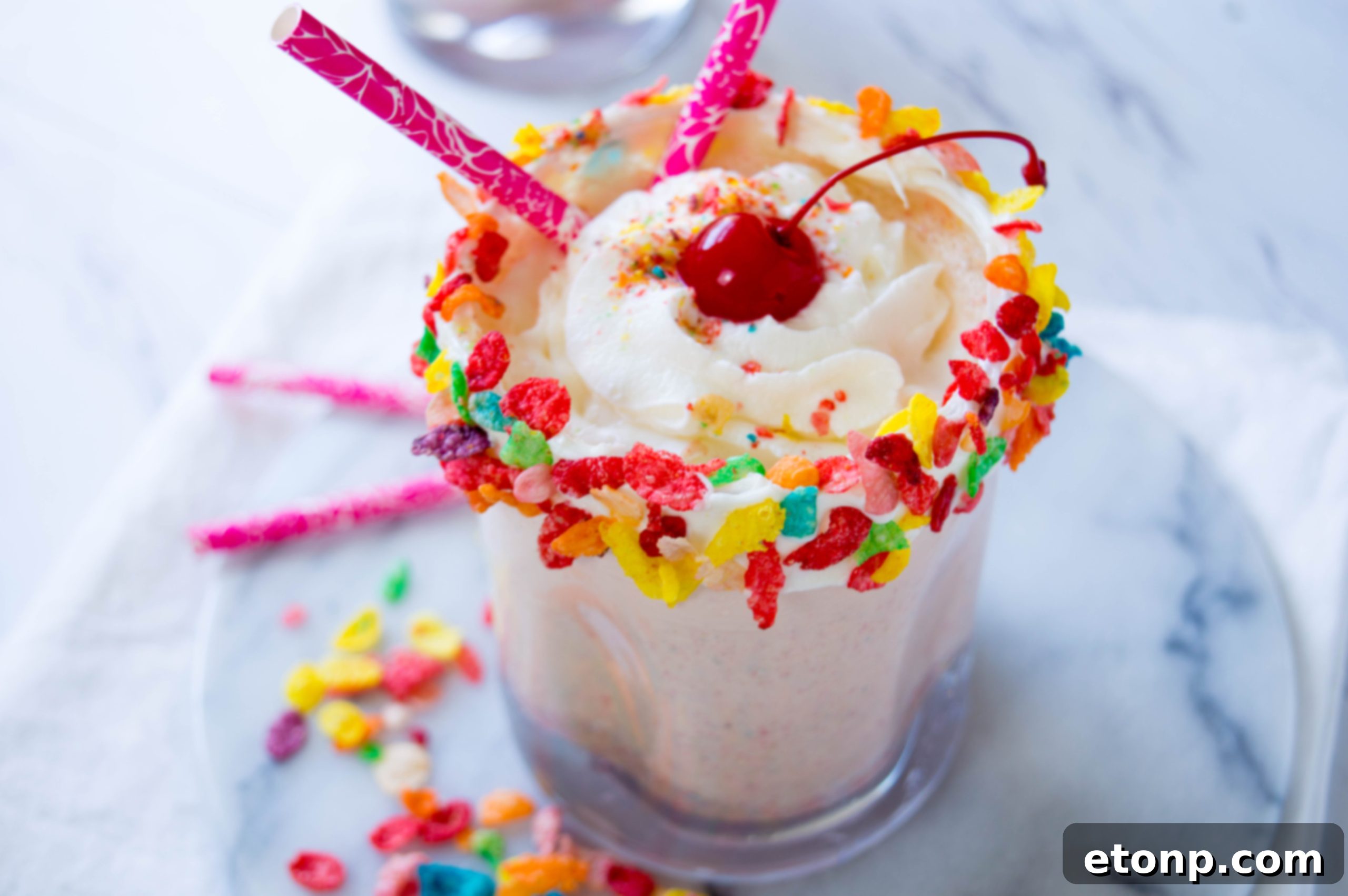 Overhead shot of a vibrant Fruity Pebbles Milkshake, garnished and ready to serve