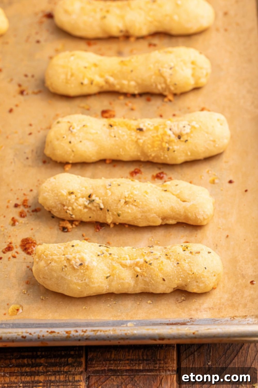 Easy Buttery Garlic Parmesan Breadsticks Two Ingredients 22 A neat line of 2-Ingredient Garlic Parmesan Breadsticks arranged on a baking tray lined with parchment paper.