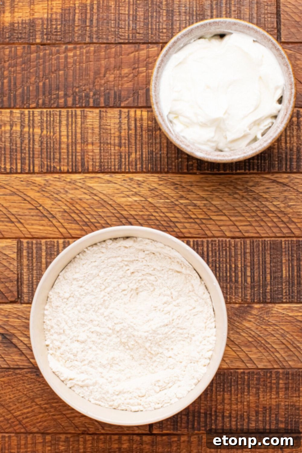 Easy Buttery Garlic Parmesan Breadsticks Two Ingredients 6 Individual bowls containing the ingredients for 2-Ingredient Garlic Parmesan Breadsticks: flour, Greek yogurt, melted butter, garlic powder, Italian seasoning, and Parmesan cheese.