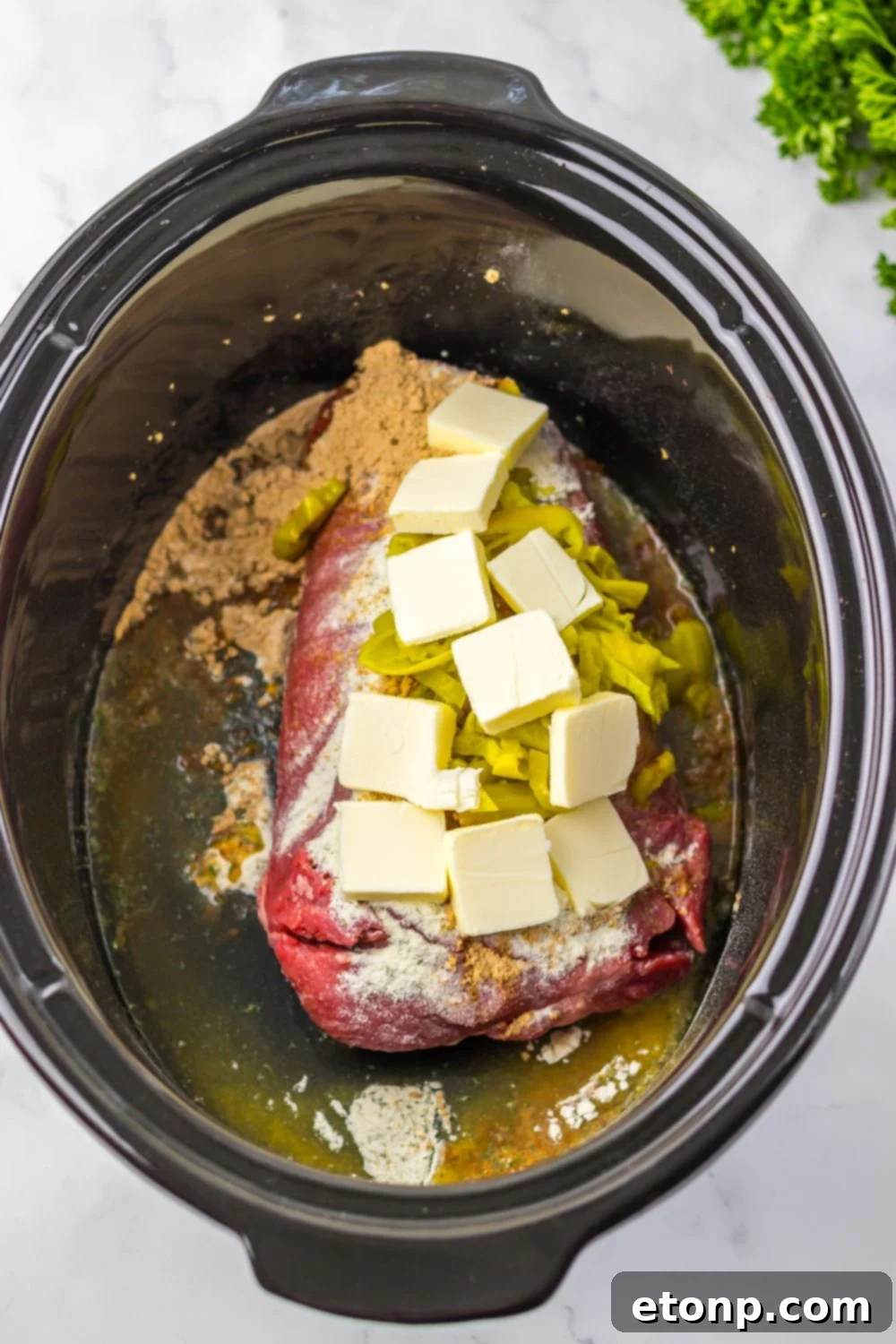 raw pot roast with sauce, butter and peppers