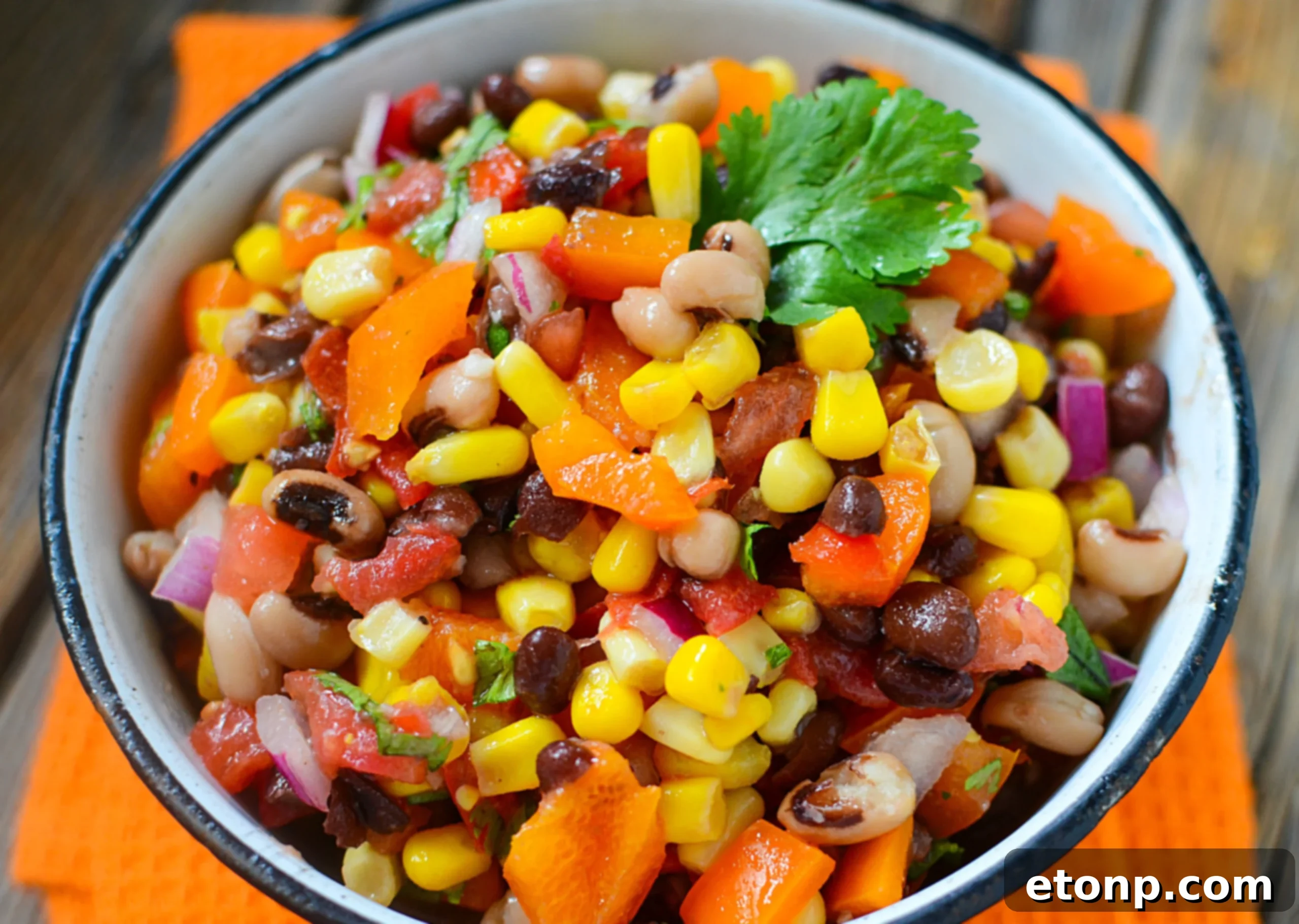 Freshly made Cowboy Caviar in a white bowl, garnished with cilantro, ready to be served.