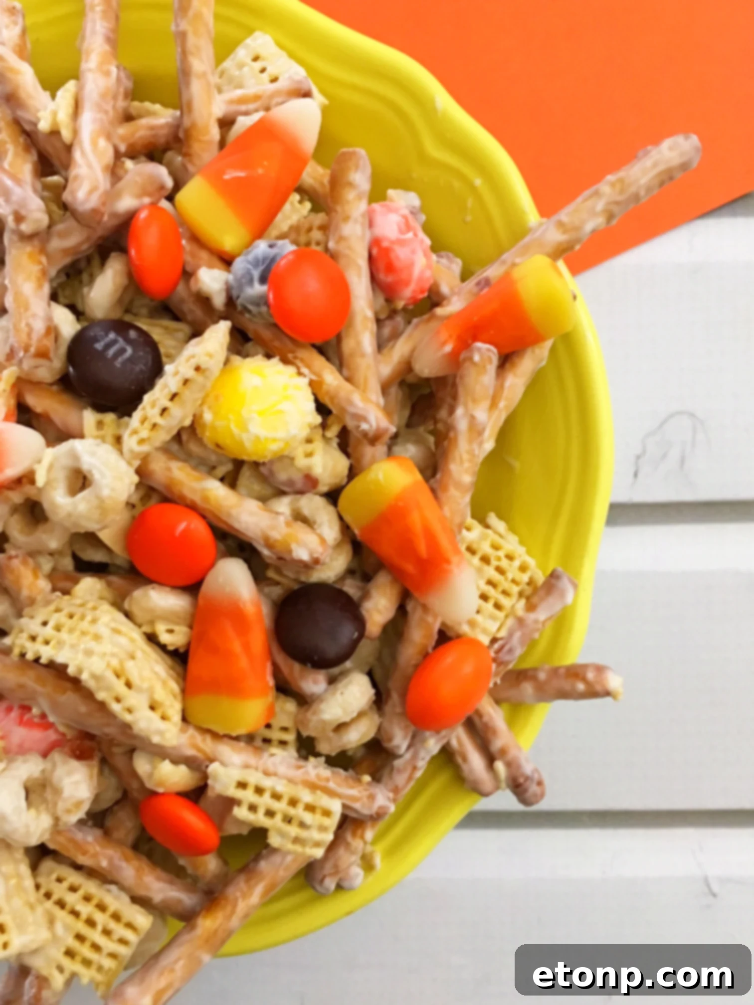 Close-up of freshly made Fall Harvest Crack, showcasing the white chocolate coating and colorful fall candies interspersed with salty snacks.