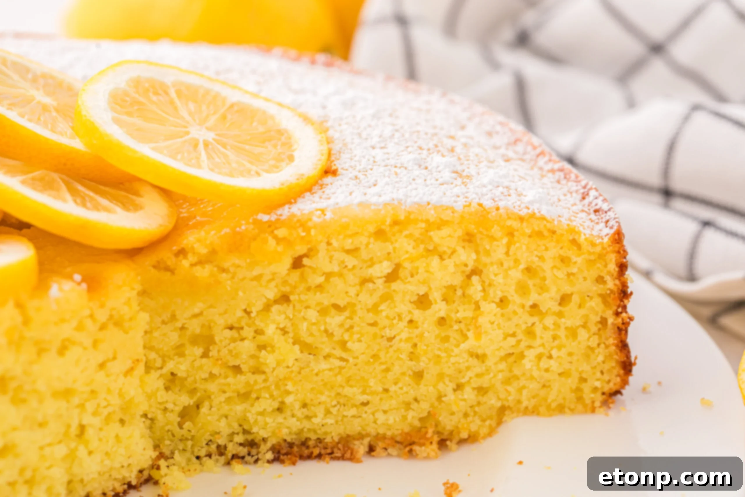 Effortless Italian Lemon Ricotta Cake: Light and Lemony Perfection 23 A delicious Italian Lemon Ricotta Cake, already sliced, rests on a plate with a few pieces missing, hinting at its popularity and how quickly it's enjoyed.
