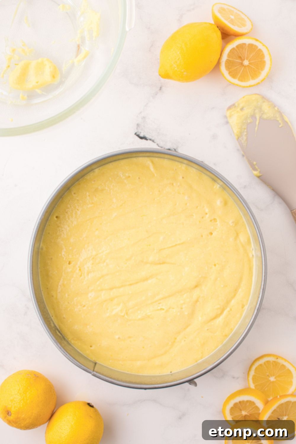 Effortless Italian Lemon Ricotta Cake: Light and Lemony Perfection 9 The smooth, yellow raw cake batter for the Lemon Ricotta Cake is poured into a round baking pan, ready for the oven.