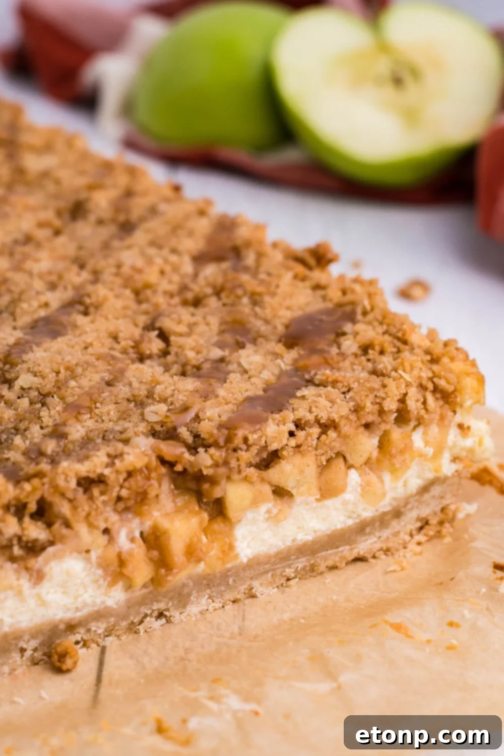 Caramel Apple Cheesecake Bars on table with a few cut off