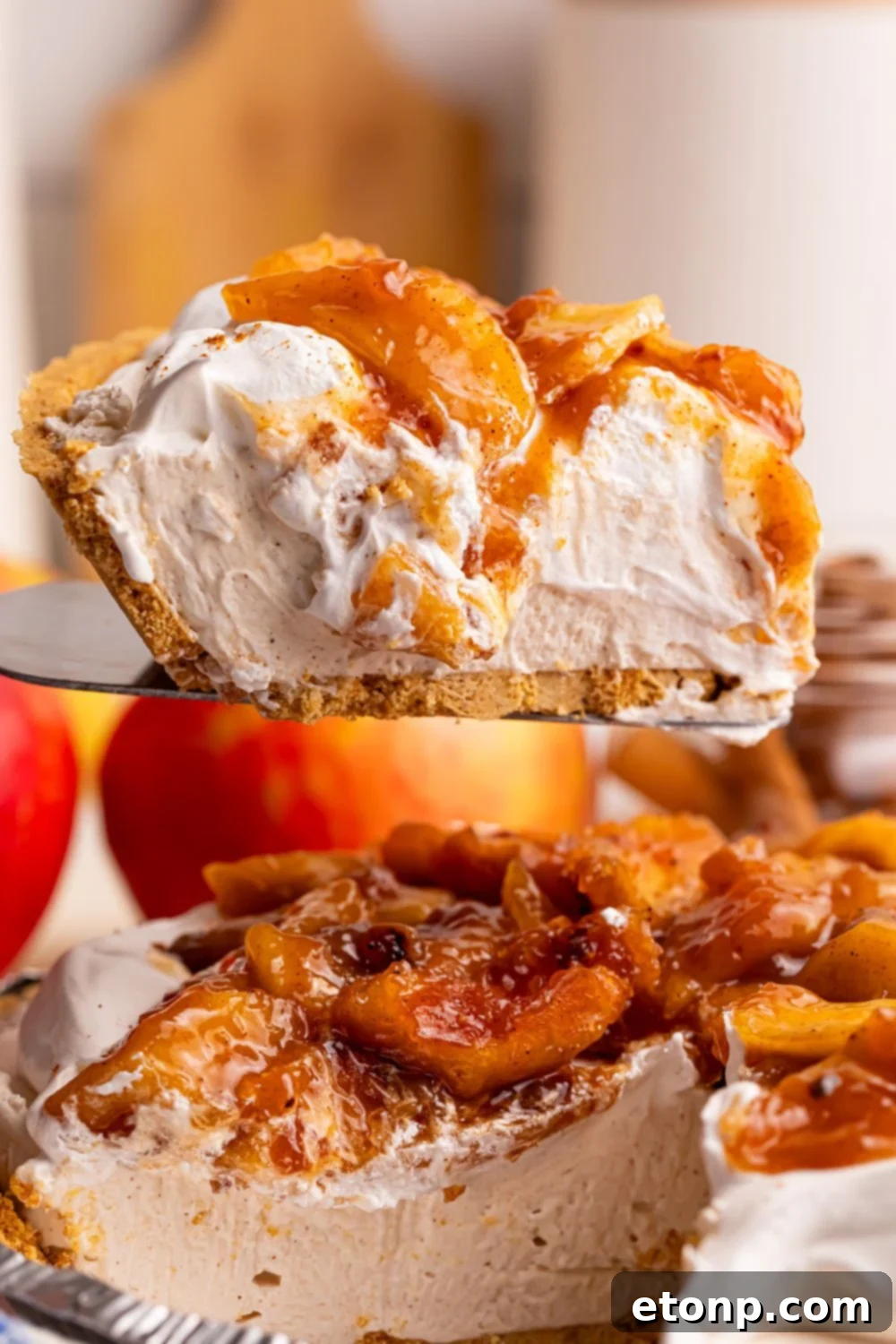No Bake Apple Cheesecake pie being lifted out of pie plate with spatula 