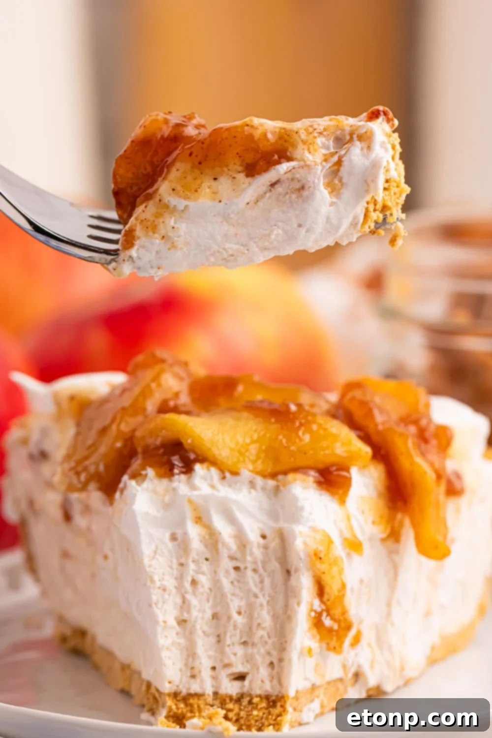 plate with a slice of No Bake Apple Cheesecake pie and a fork with one bite on fork 