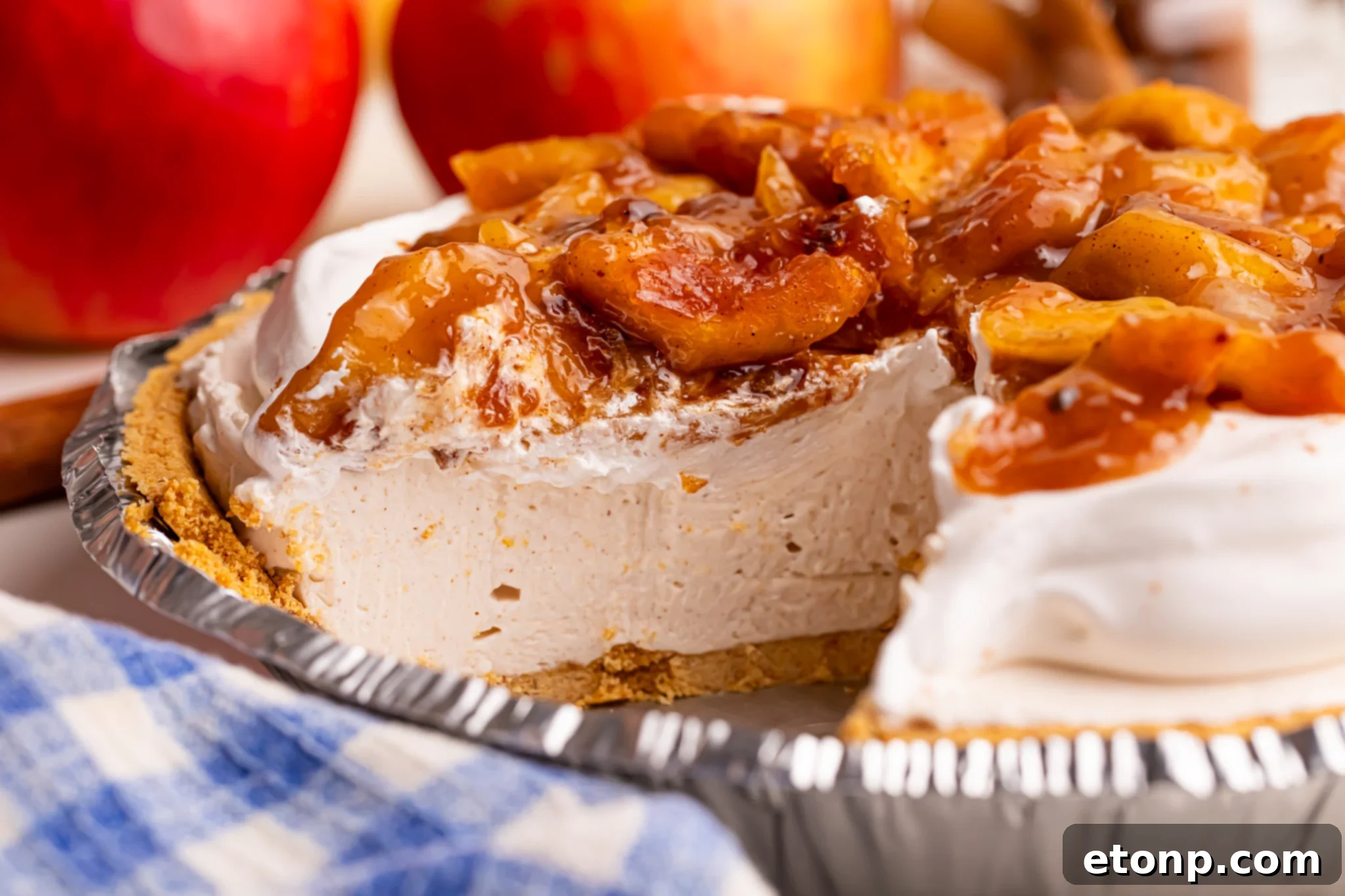 side view of the No Bake Apple Cheesecake pie in the pie plate with a piece missing 