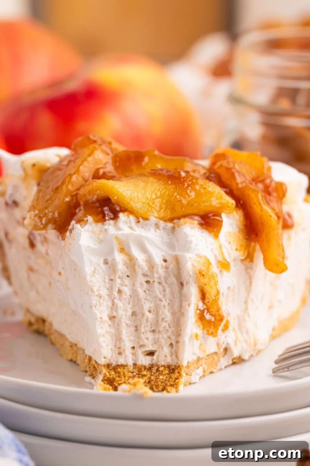 slice of No Bake Apple Cheesecake pie with a fork bite taken out of the cake to show how creamy it is 