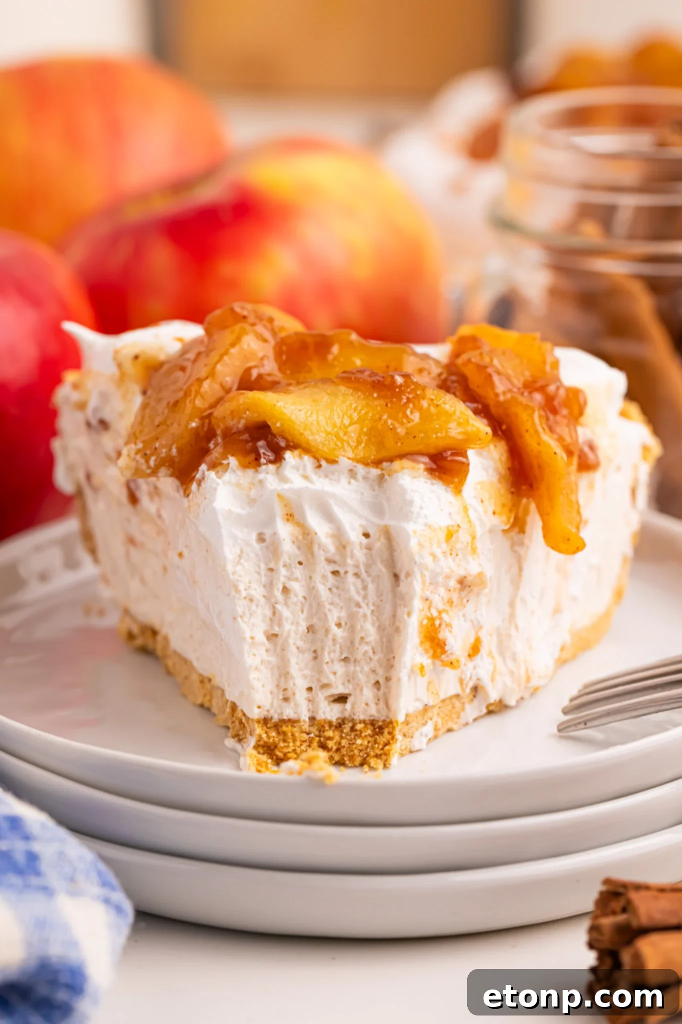 Slice of the No Bake Apple Cheesecake pie on a stack of small white serving plates