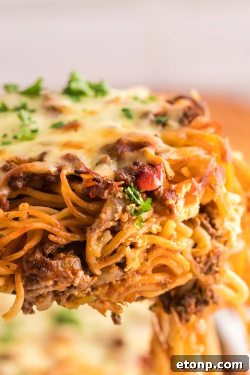 lifting up Million Dollar Spaghetti Casserole from the pan 