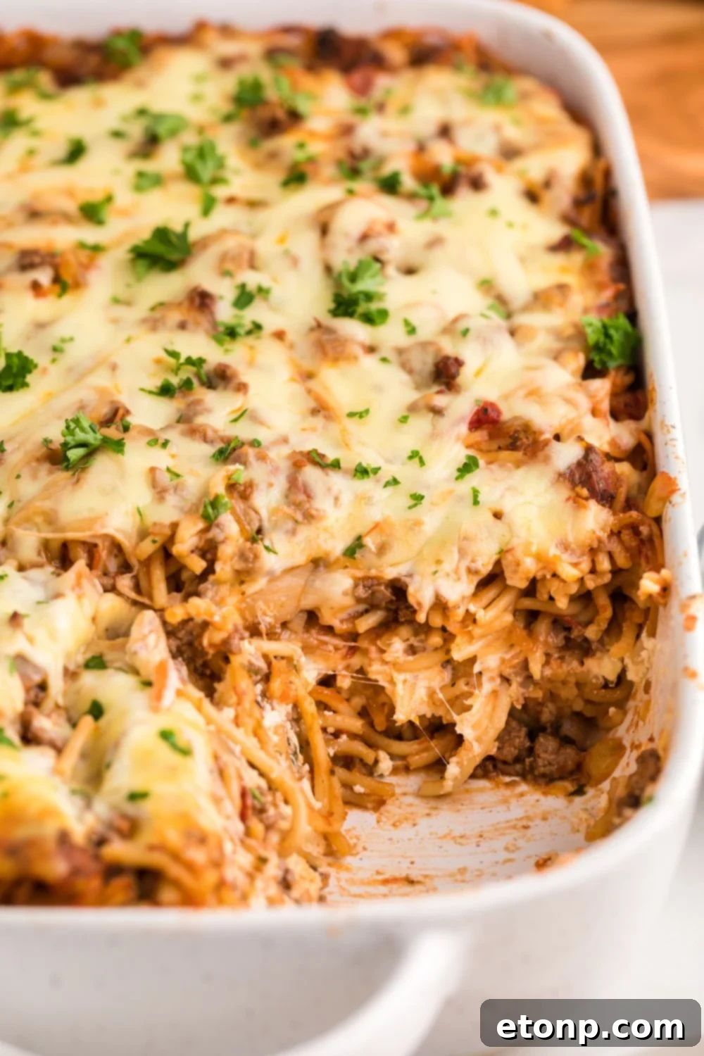 Million Dollar Spaghetti Casserole in a pan with some of the casserole removed from pan 