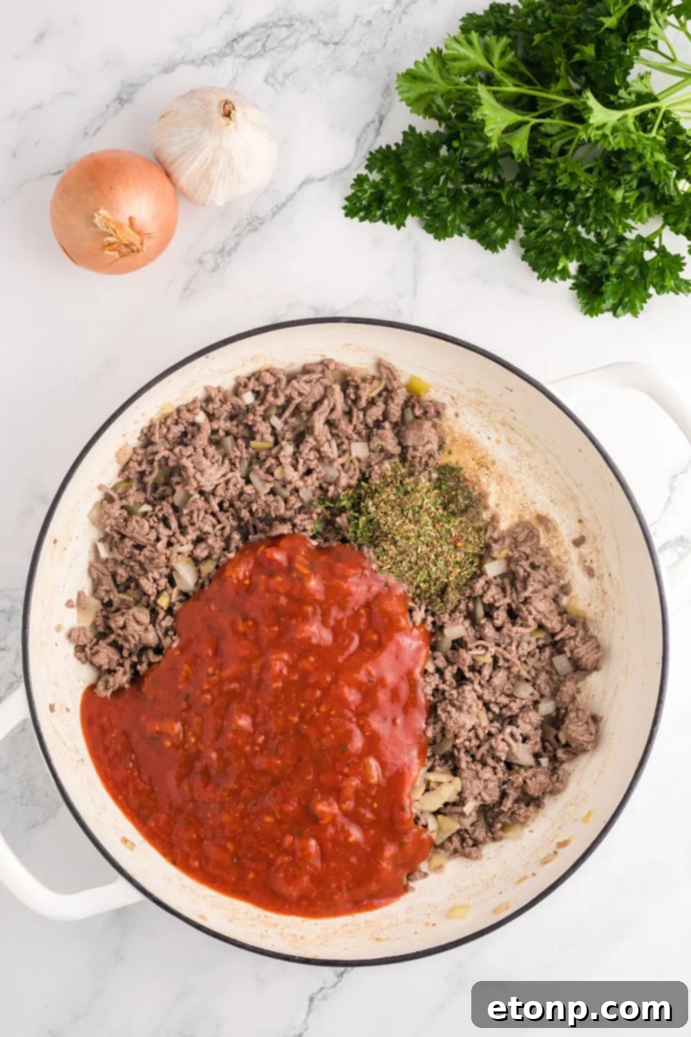 ground beef with sauce and spice in the pot for Million Dollar Spaghetti Casserole