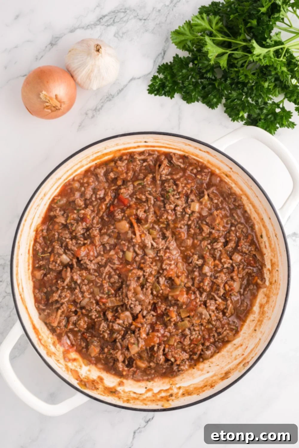 ground beef sauce in a skillet being cooked for Million Dollar Spaghetti Casserole