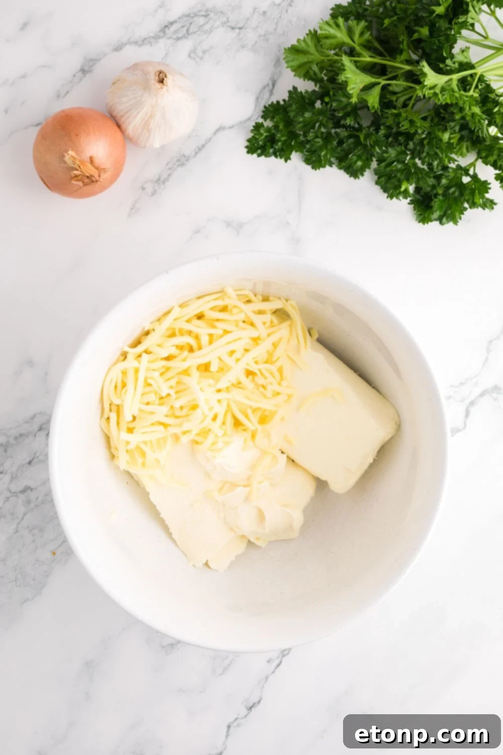 cream cheese and shredded cheese in a glass bowl