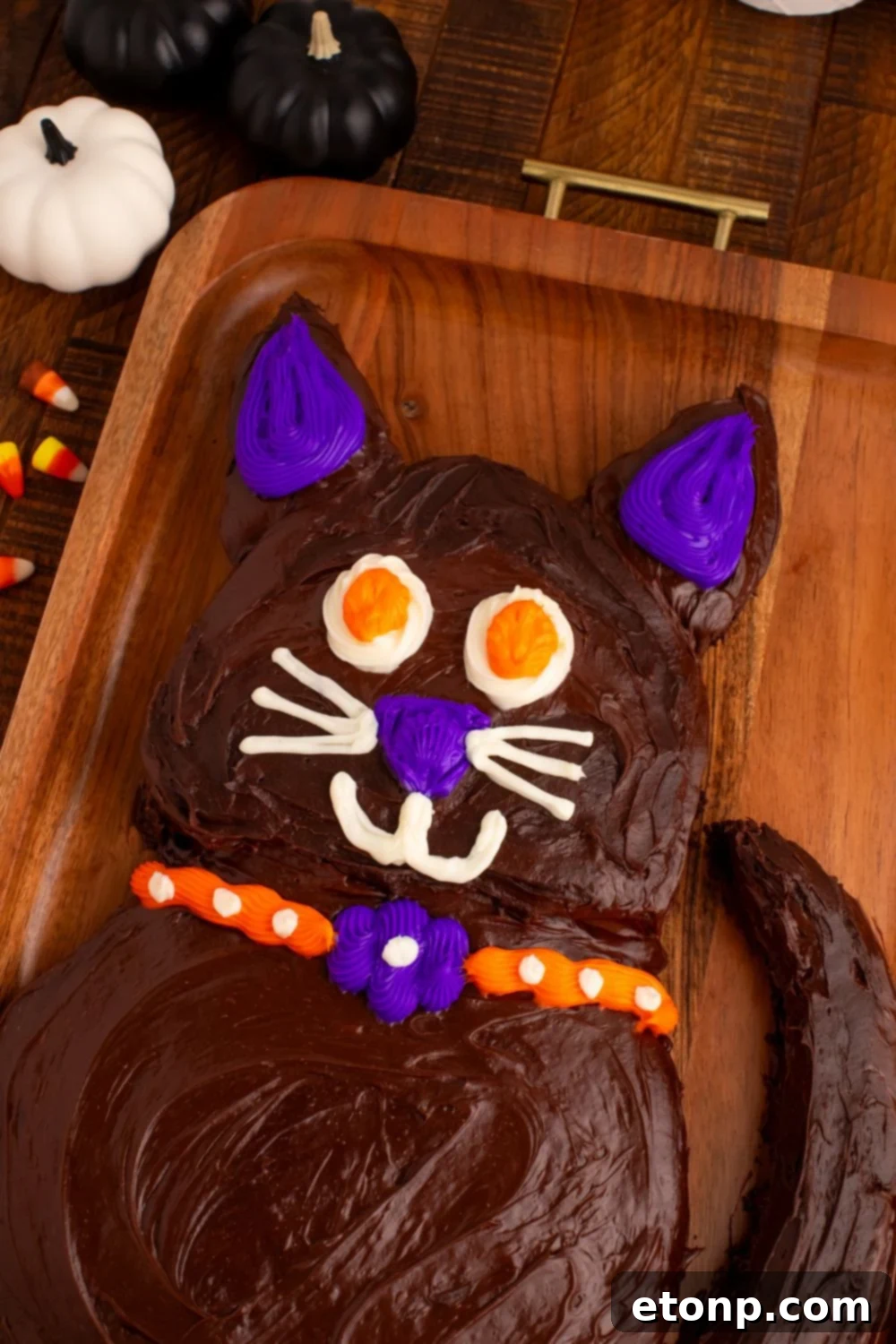 The Easy Halloween Black Cat Cut Out Cake sitting majestically on a wooden tray, a festive focal point on the table.