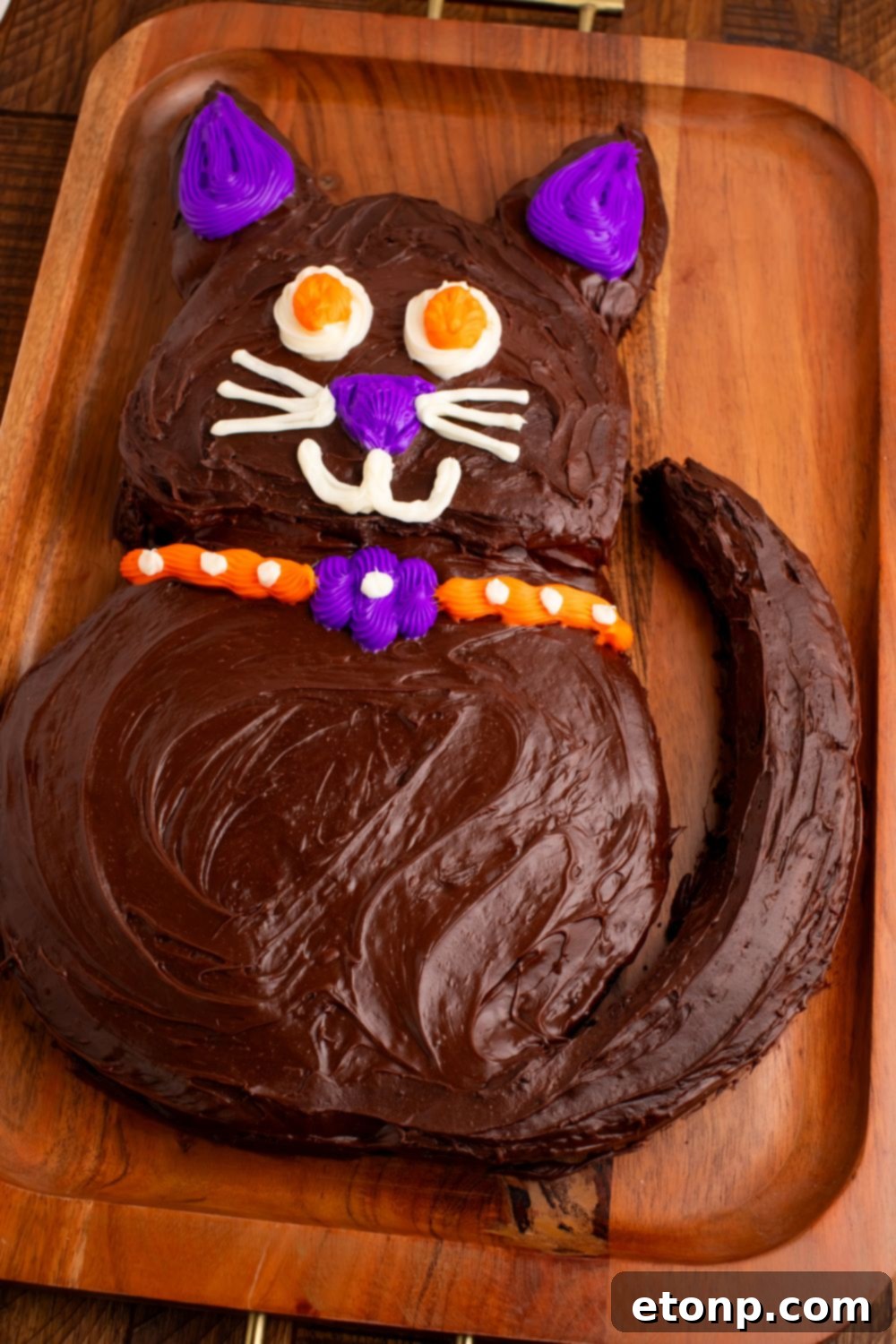 A full side view of the Easy Halloween Black Cat Cut Out Cake, elegantly displayed on a tray, showcasing its complete and charming silhouette.