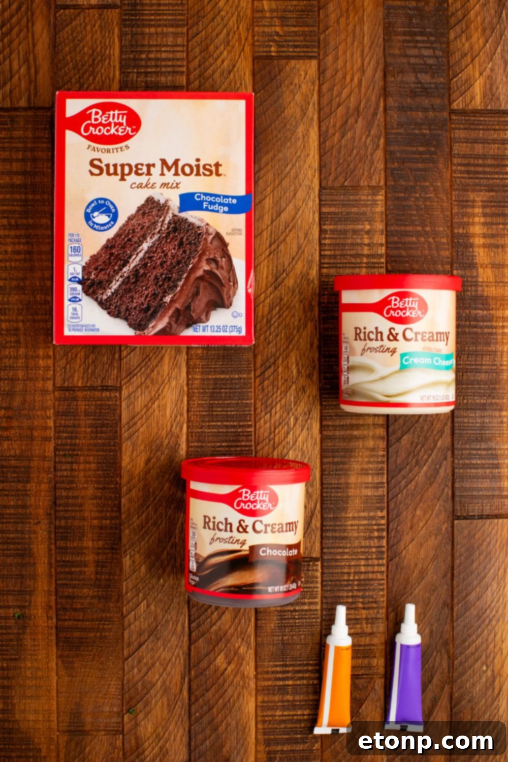 A selection of ingredients for the Easy Halloween Black Cat Cut Out Cake, neatly arranged in containers on a wooden table.
