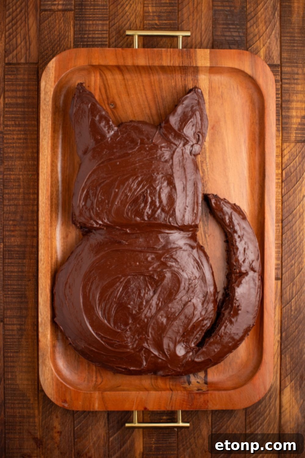 A chocolate-frosted Easy Halloween Black Cat Cut Out Cake, fully covered in dark frosting but yet to receive its festive decorations.