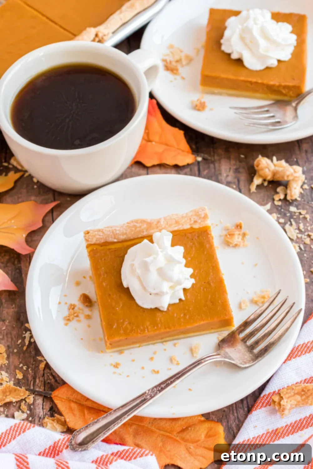 Effortless 4-Ingredient Sheet Pan Pumpkin Pie 17 wooden table decorated like fall with plates of square Sheet Pan Pumpkin Pie slices on each plate and a cup of coffee in between the plates