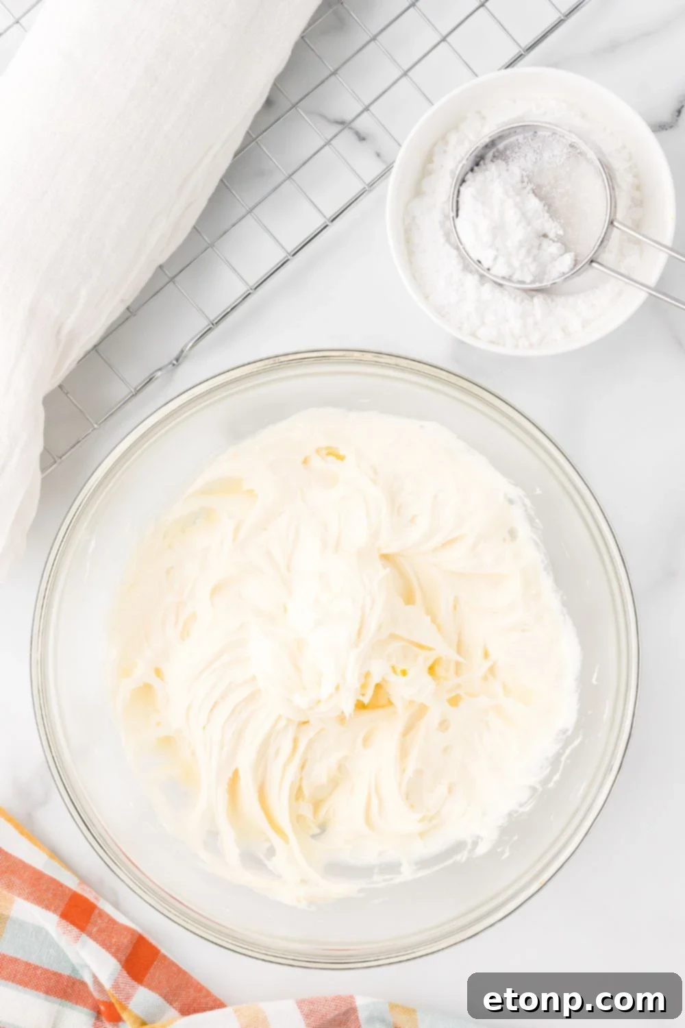 cream cheese filling in a glass bowl sitting on a marble counter