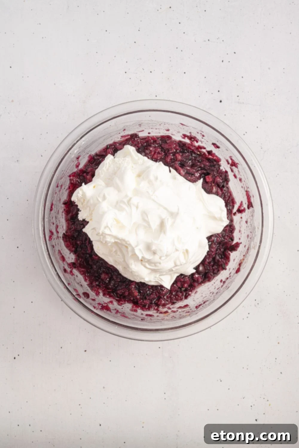 white counter with a cranberry mixture topped with a creamy whipped topping mixture 