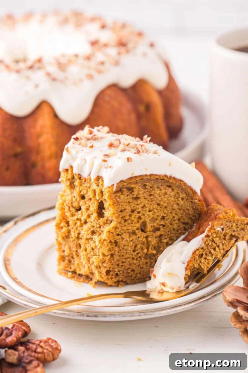 plate with a slice of Pumpkin Bundt Cake on it with a fork with a bite of the cake on it sitting to side 
