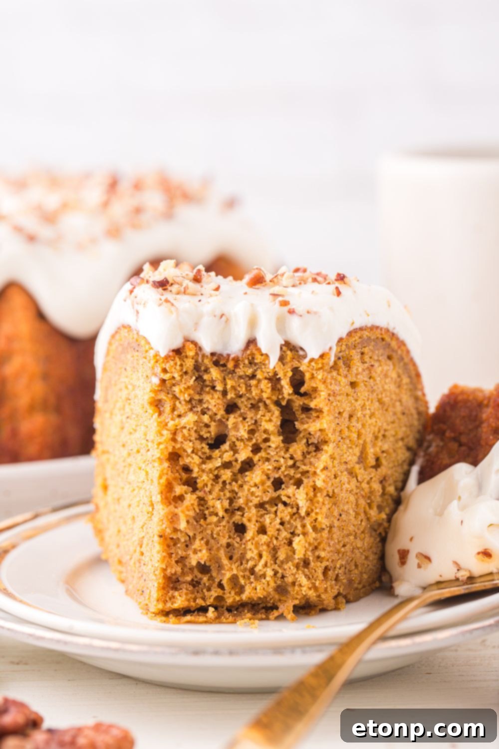 white plate with a slice of Pumpkin Bundt Cake on it with a bite taken out of it 