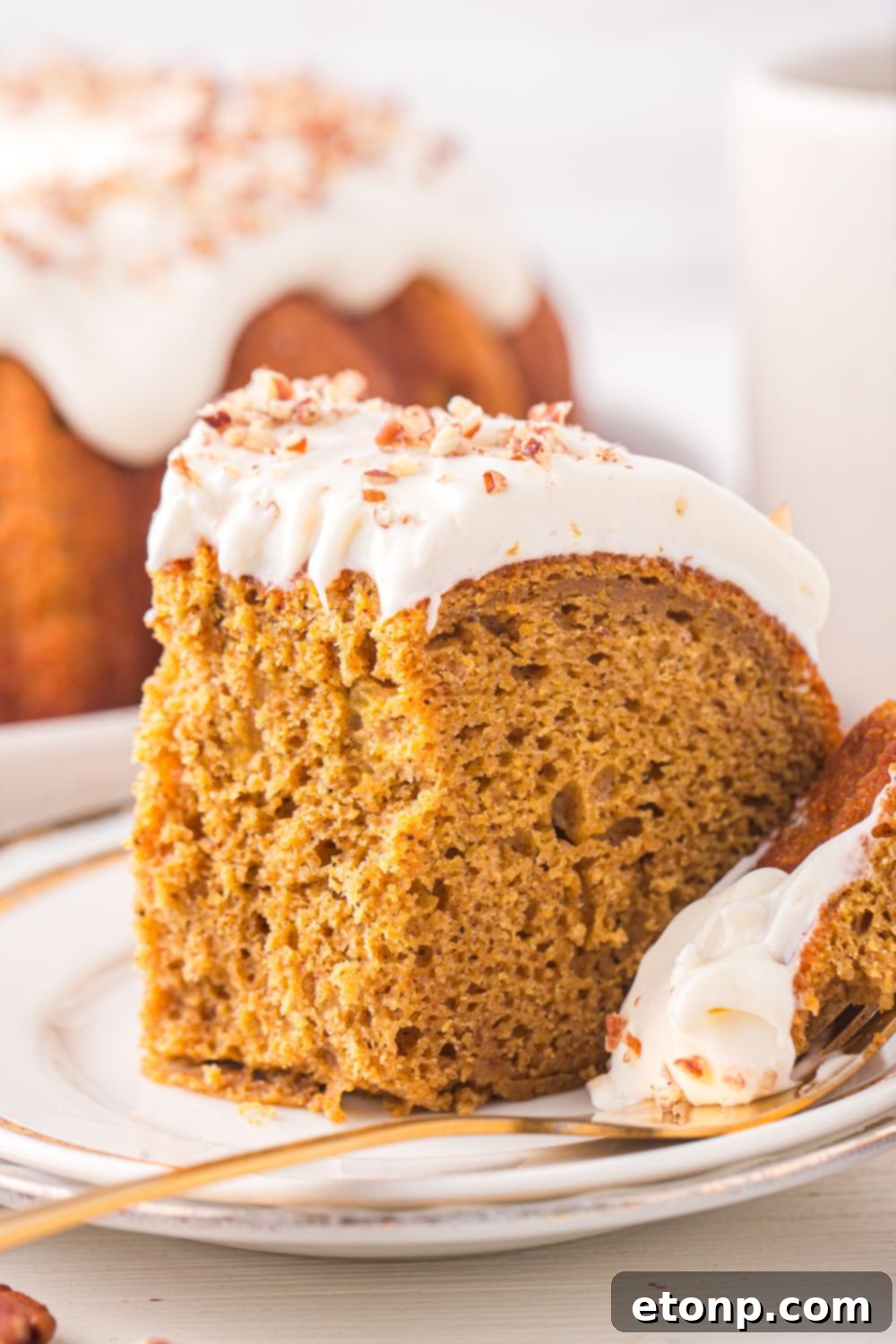 Pumpkin Bundt Cake on a white plate with some of the cake on the silver fork beside it 