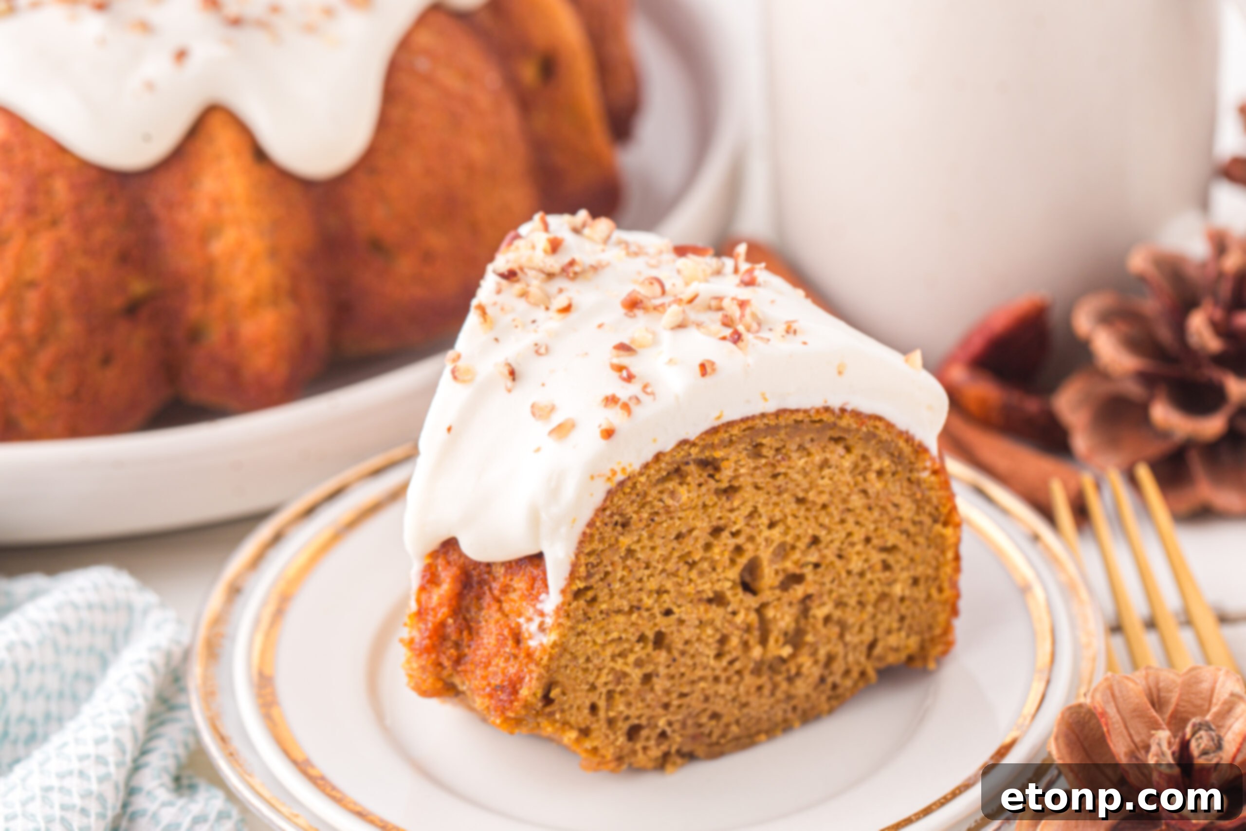 Slice of the Pumpkin Bundt Cake on a white serving plate topped with nuts 
