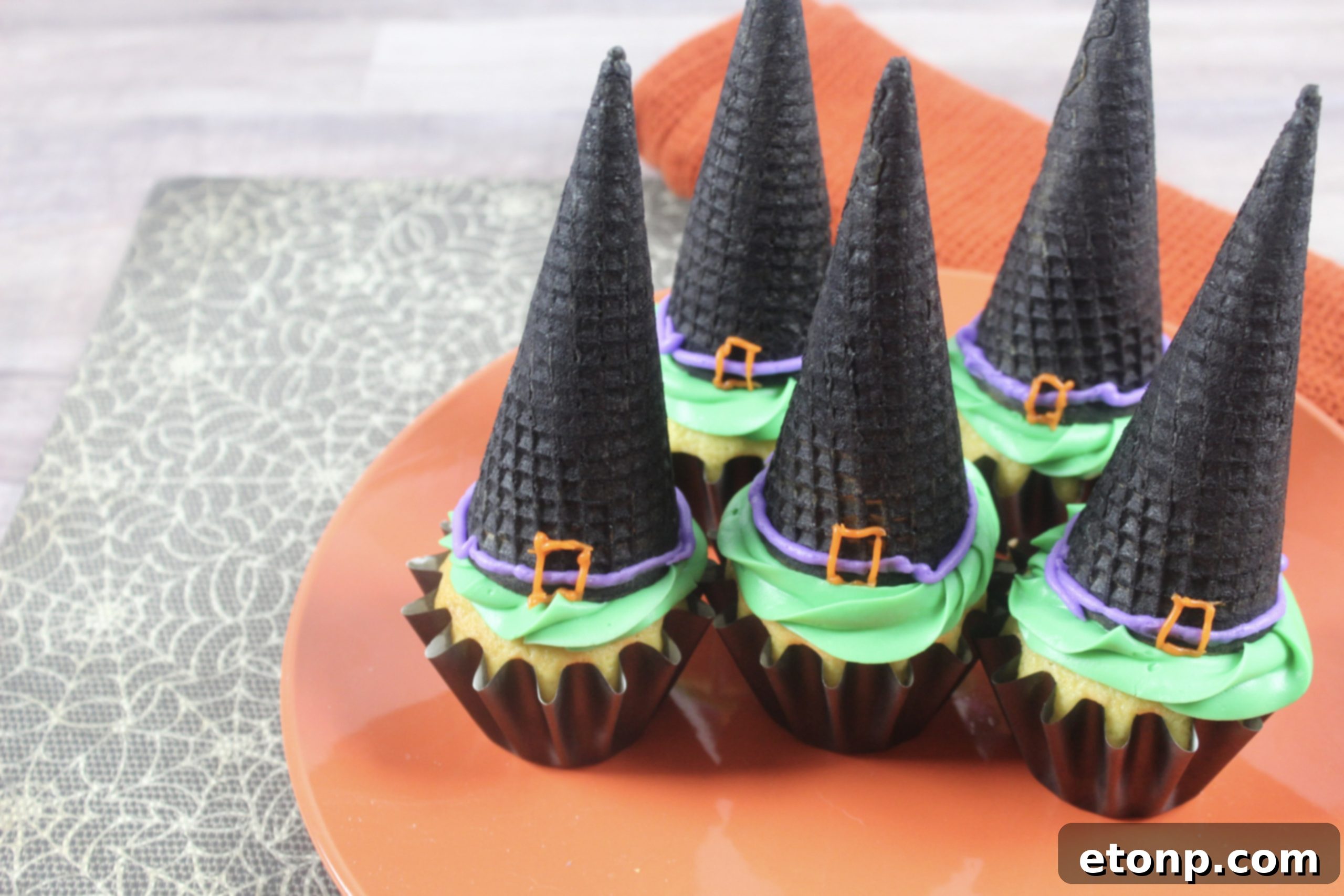 A collection of expertly decorated black sugar cone witch hats, showcasing the buckle detail