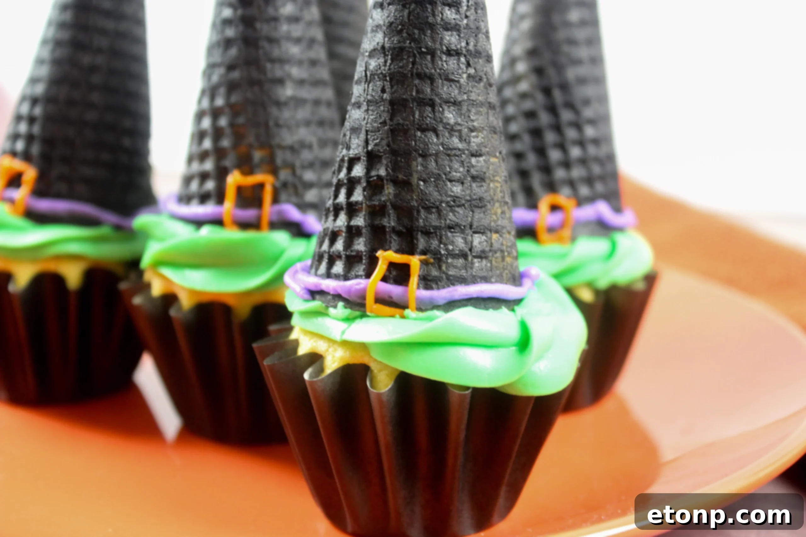 Charming witch hat cupcakes arranged on a plate, ready to enchant your Halloween guests