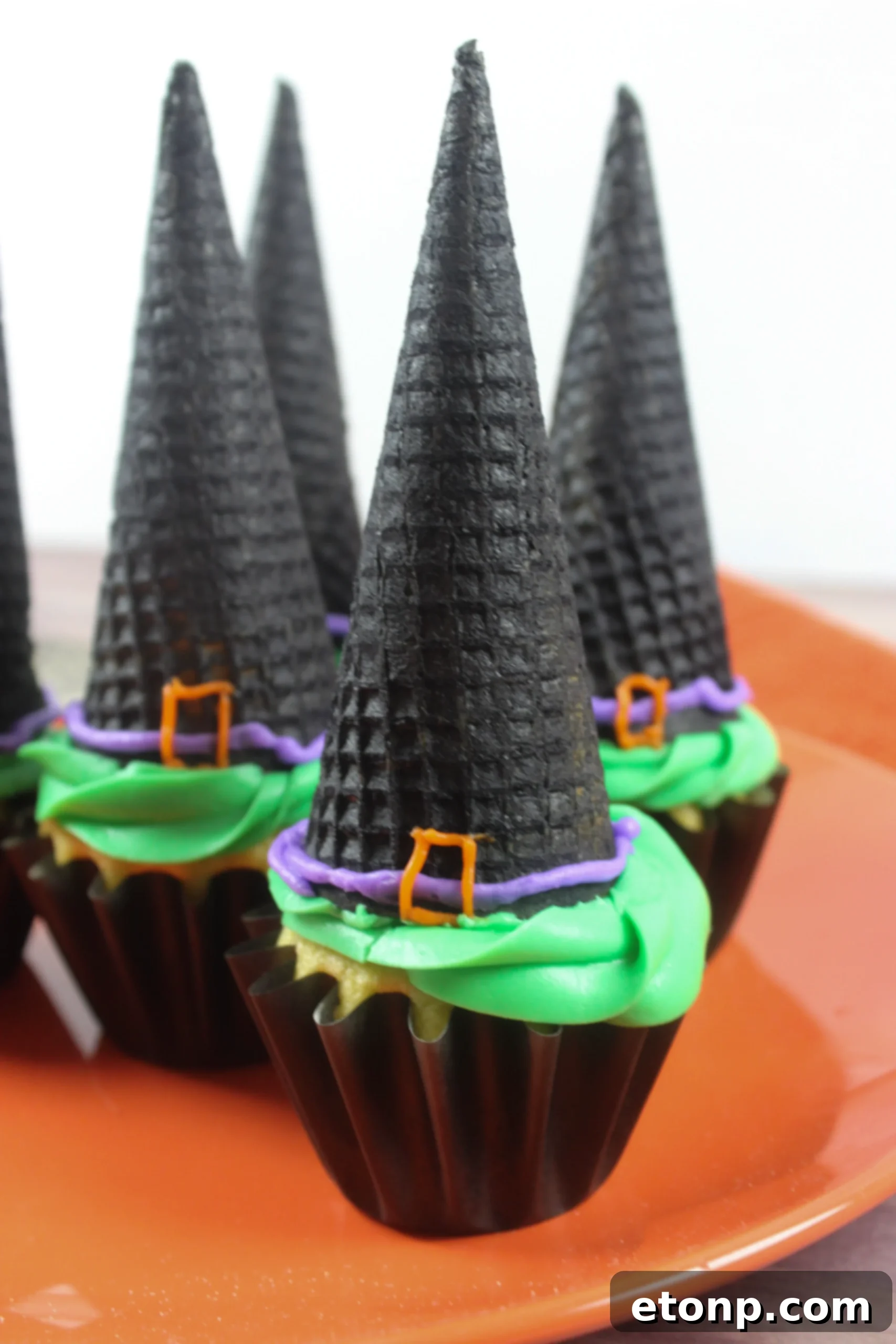 A vertical shot of a fully assembled witch hat cupcake, highlighting its festive design