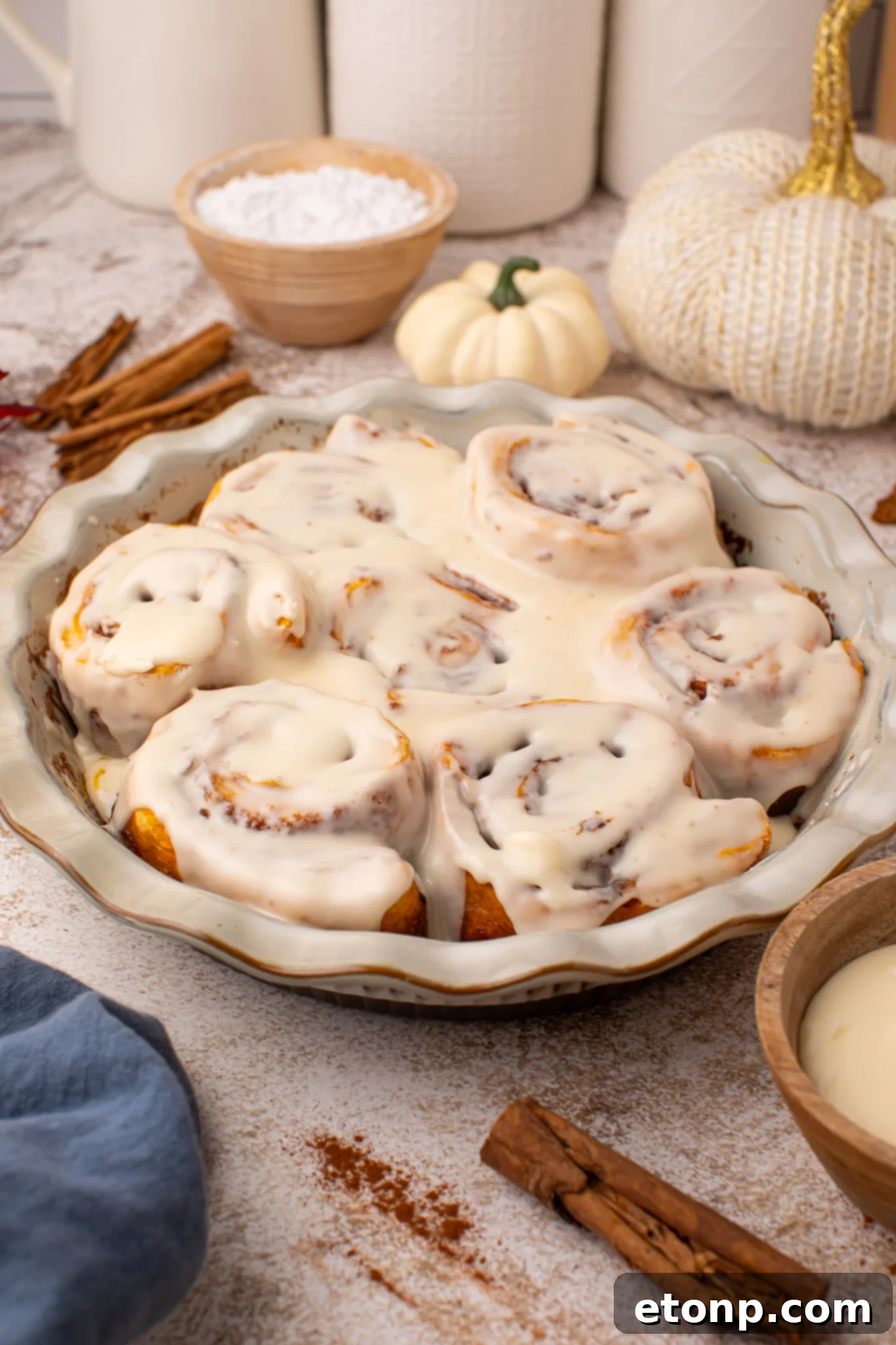 Effortless 2-Ingredient Pumpkin Cinnamon Rolls No Yeast 2 Easy 2 Ingredient Pumpkin Cinnamon Rolls in a baking dish smothered in icing